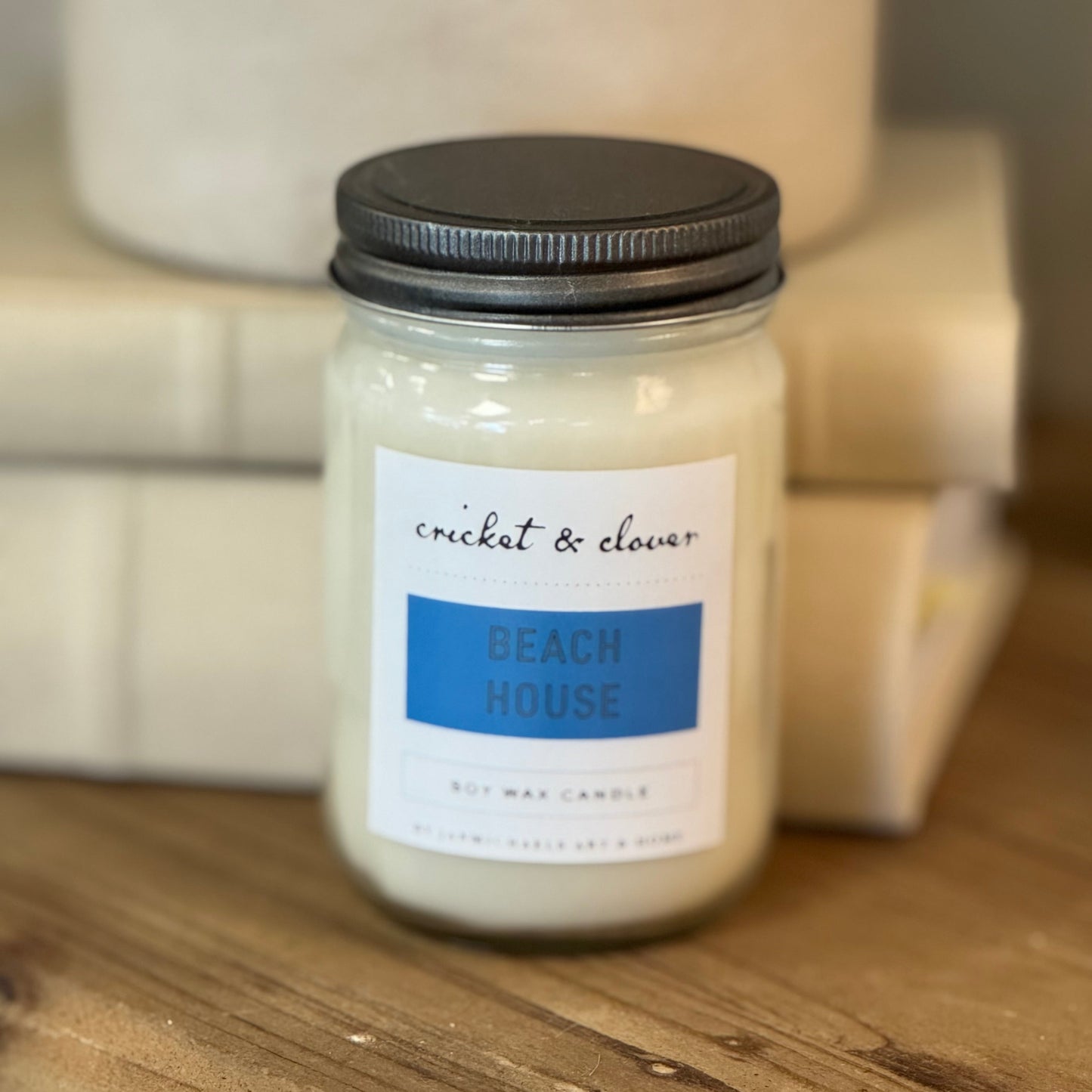 Mason jar with silver lid, white label with blue.