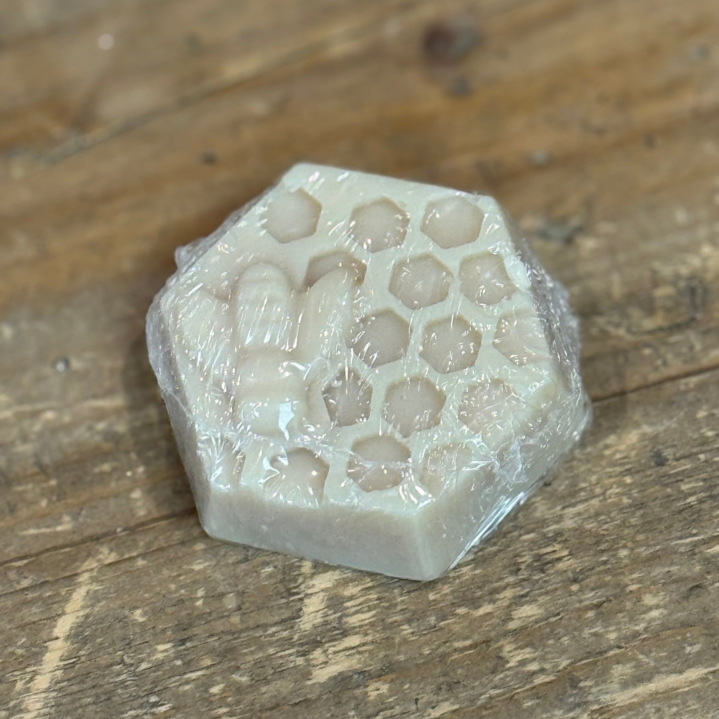 Hexagon shaped honeycomb design soap with a bee molded from soap on top.