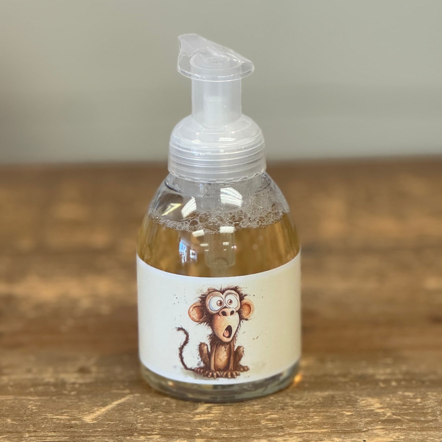 clear bottle with a hand pump and a monkey on the label