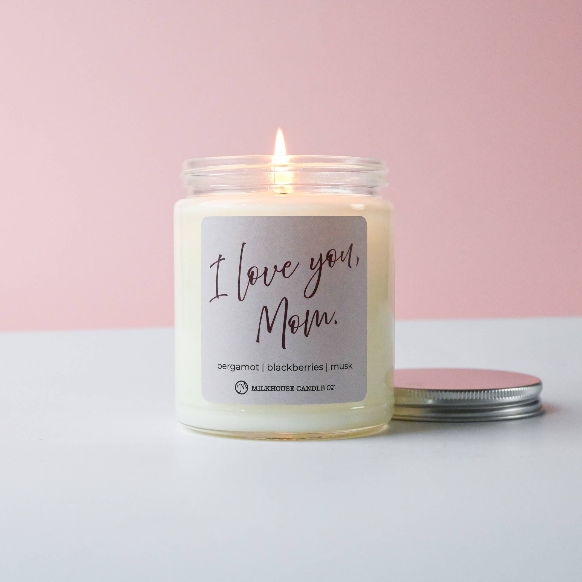 Candle with 'I Love You, Mom' label on a pink and white background
