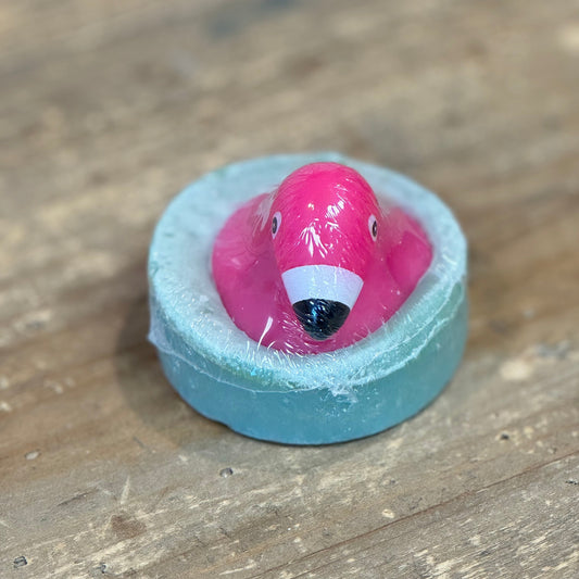 round light blue soap with a pink rubber flamingo on it