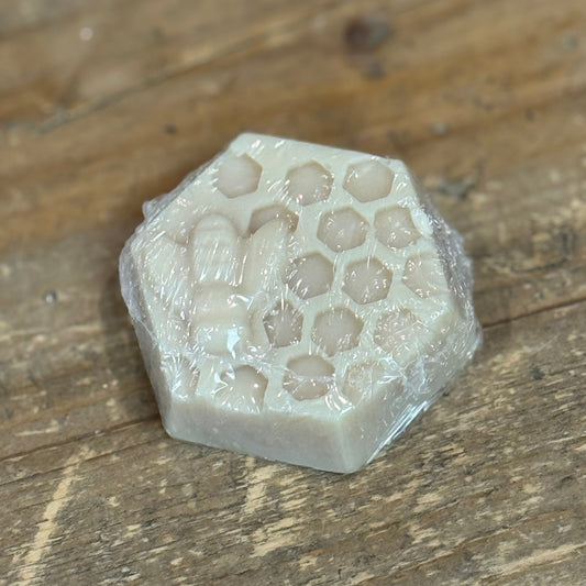 Hexagon shaped honeycomb design soap with a bee molded from soap on  top.