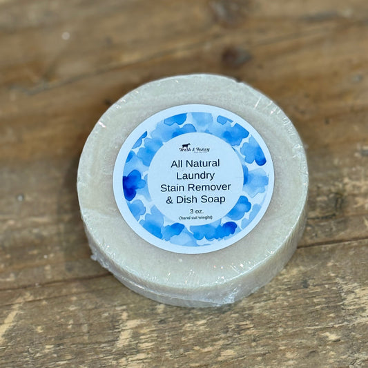 Cream colored round soap with a blue label