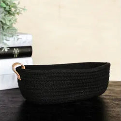 Black woven basket with handles on a dark surface