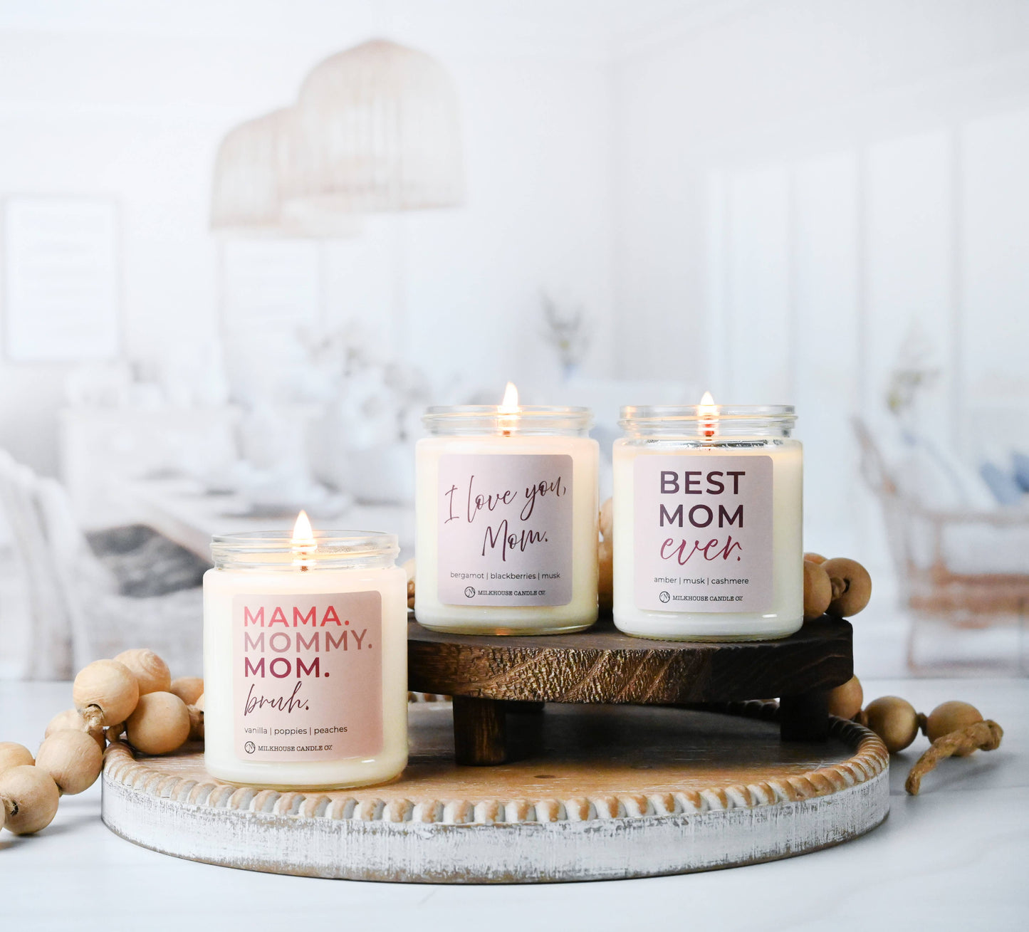 Three candles with personalized messages on a wooden stand against a light background
