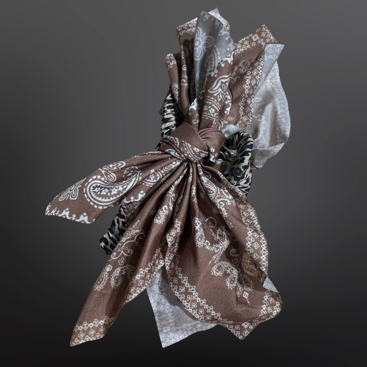 Brown patterned fabric tied into a knot against a dark background